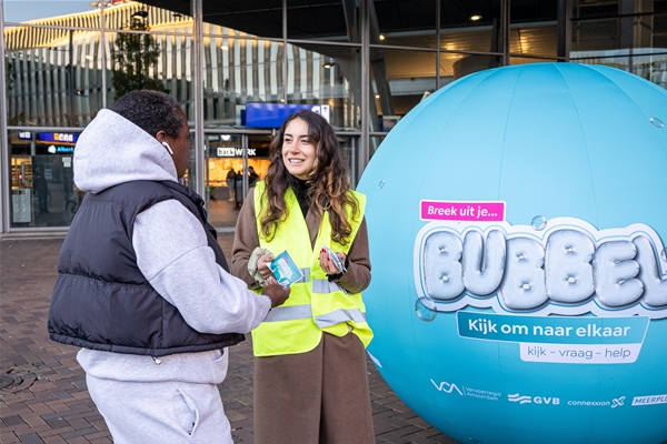 Foto van campagneteam in gesprek met reiziger voor Breek uit je Bubbel