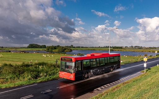 Foto van R-net bus door de weilanden met schapen naar Marken