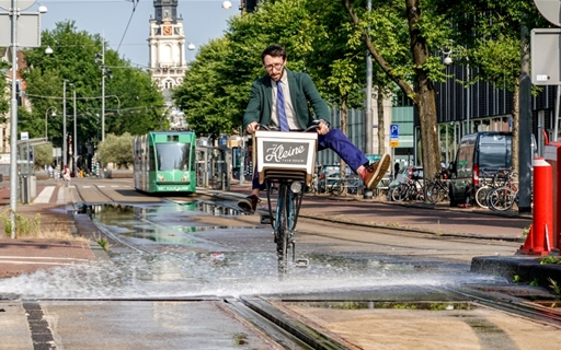 Man die door een plas fietst